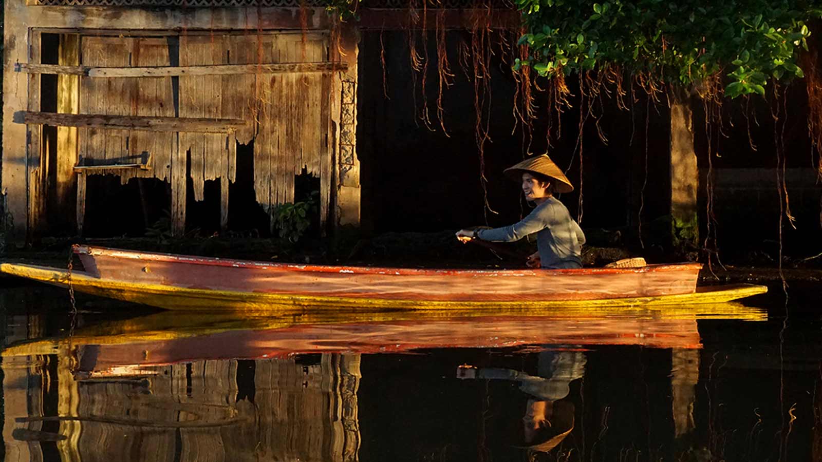 ชายพายเรือและเรือพายลำท้าย ๆ ในคลองบางกอกใหญ่